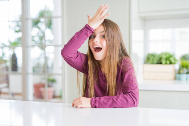 istock Beautiful young girl kid on white table surprised with hand on head for mistake, remember error. Forgot, bad memory concept. 1139071035