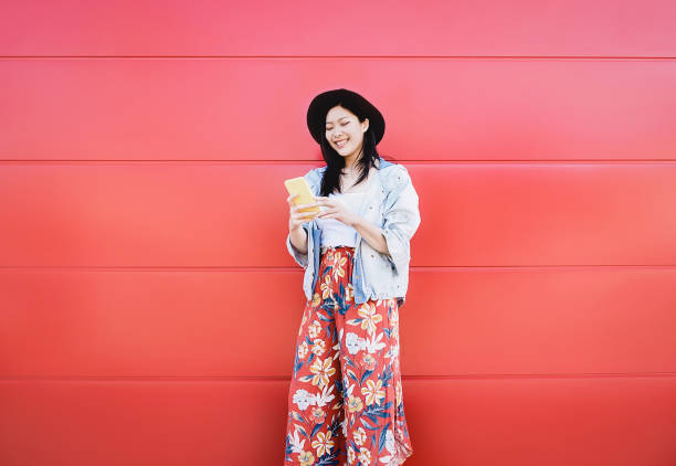happy asian girl using mobile phone outdoor - chinese social influencer having fun with new trends smartphone apps - generation z, media, technology and youth millennial people lifestyle - japanese girl imagens e fotografias de stock