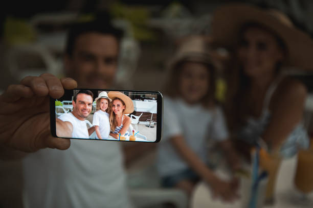 istock Cheerful parents photographing with child on mobile 1139076089