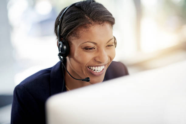 Her customer's love that she loves her job Shot of a young woman using a headset and computer in a modern office answering photos stock pictures, royalty-free photos & images