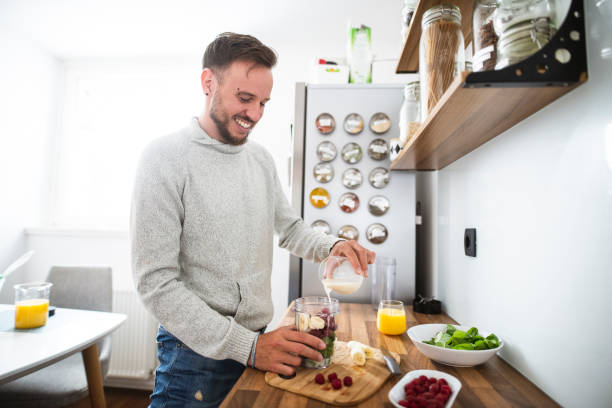 istock Young Caucasian man preparing a healthy fruit breakfast in the kitchen 1139083035