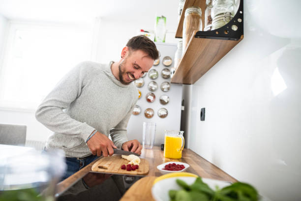 istock Young Caucasian man preparing a healthy fruit breakfast in the kitchen 1139083676