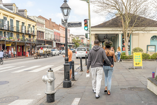 New Orleans, LA / USA - February 17, 2019: A beautiful young couple explores the French Quarter, near the French Market, on a winter day. New Orleans is known as a very romantic travel destination.