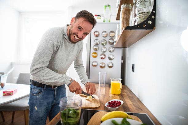 istock Young Caucasian man preparing a healthy fruit breakfast in the kitchen 1139083934