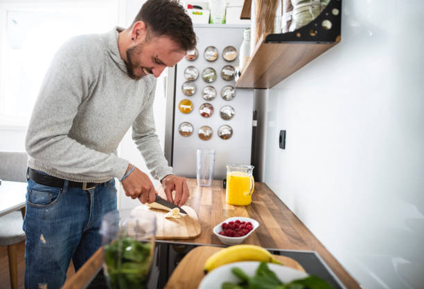 istock Young Caucasian man preparing a healthy fruit breakfast in the kitchen 1139083996