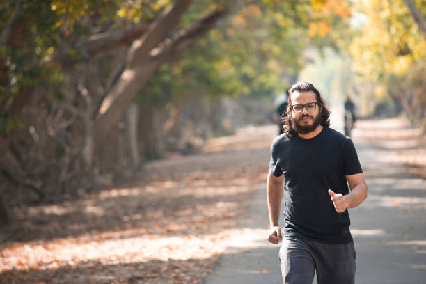 Hipster man at park Happy young man running at public park indian man walking in park stock pictures, royalty-free photos & images