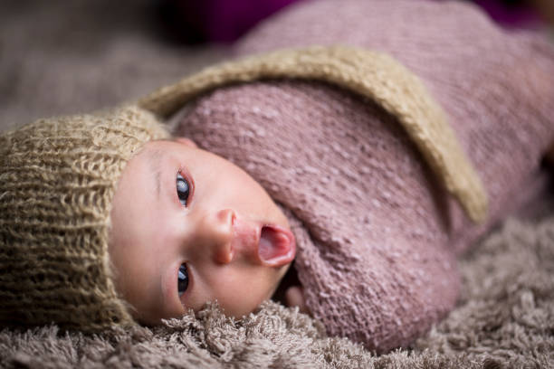 bébé nouveau-né enveloppé dans la couverture de fourrure - baby yawning asian ethnicity newborn photos et images de collection