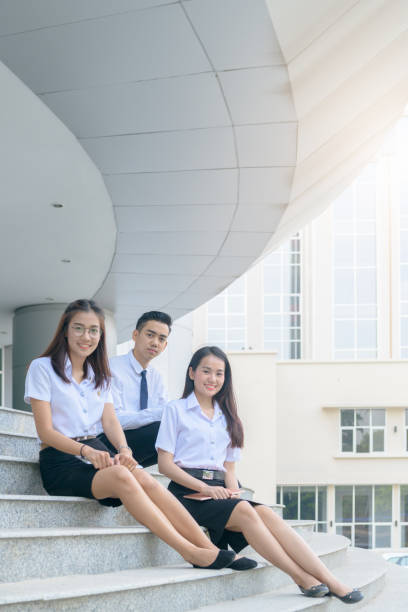 大学で制服立地の幸せなアジアの学生 - collegian ストックフォトと画像