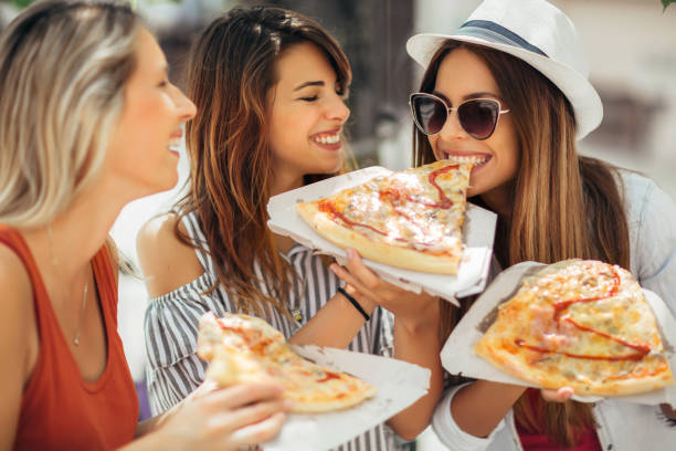 istock Three beautiful young women eating pizza after shopping, having fun together. 1139096679