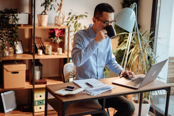 istock Businessman with paperwork using laptop and drinking coffee 1139096711