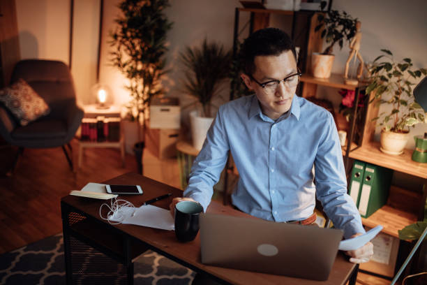 istock Businessman with paperwork using laptop and drinking coffee 1139096755