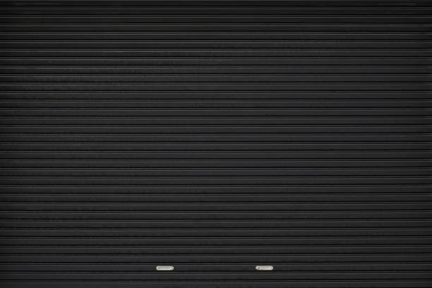 puerta de persiana negra con soporte de acero inoxidable. fondo de puerta plegable de metal negro grunge y textura. - puerta negocio fotografías e imágenes de stock