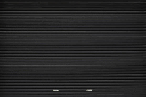 black shutter door with stainless steel holder. grunge black metal foldable door background and texture. black shutter door with stainless steel holder. grunge black metal foldable door background and texture. shutter door stock pictures, royalty-free photos & images