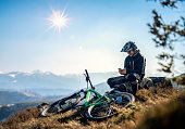 Mountain biker using a smart phone in the mountain