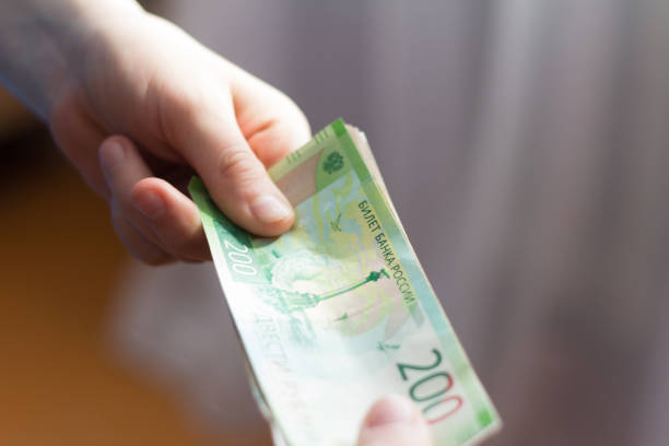 istock banknotes transferring from hand to hand,Russian rubles 1139104168