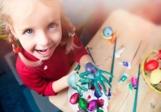 Little girl painting Easter eggs