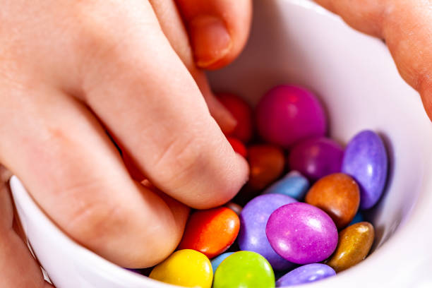 istock Child eating chocolate lentels from white bowl 1139104422