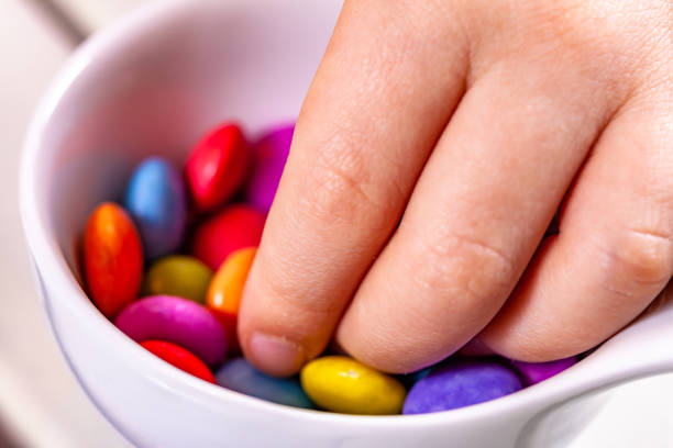 istock Child eating chocolate lentels from white bowl 1139104502