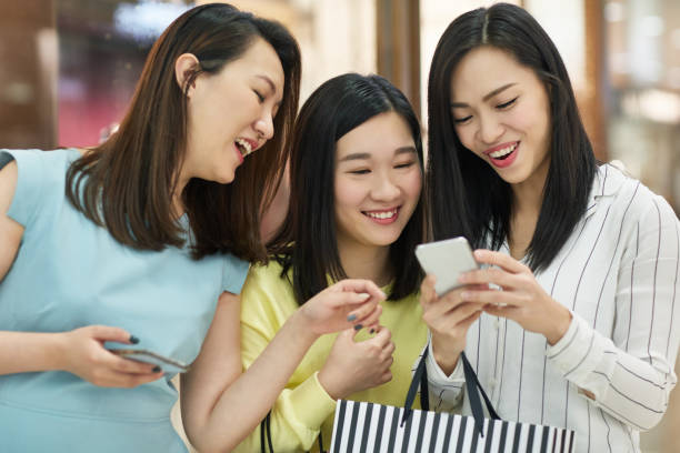 istock Cheerful friends using mobile phone in store 1139104897