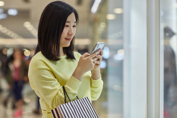 istock Woman using mobile phone in shopping mall 1139104901