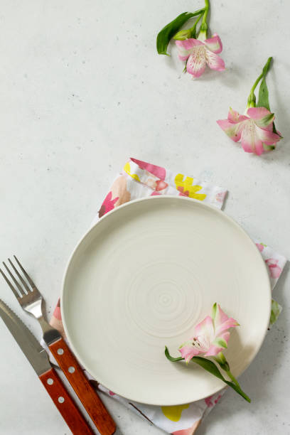 istock Spring or Mother's Day table setting. Plate, cutlery and napkin on white stone table. Top view flat lay background with copy space. 1139106182