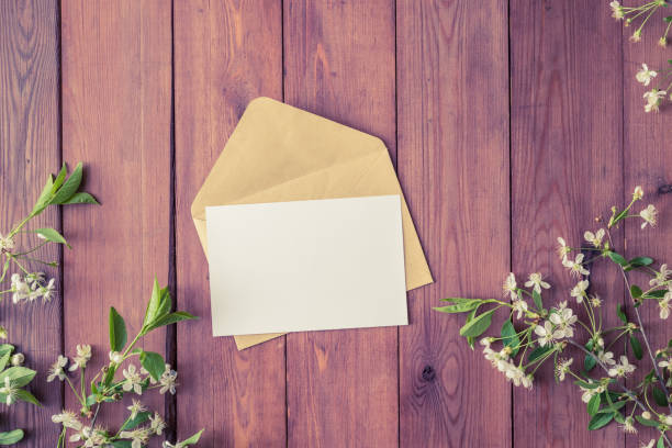 istock Mockup white greeting card and envelope with spring white flowers on a wooden background 1139106271