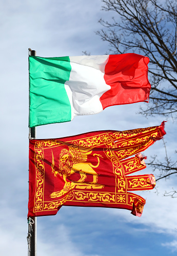 Venice, VE, Italy - January 4, 2019: Italian flag and the Flag of Veneto Region with winged Lion