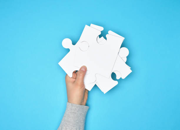 istock female hand holding a stack of large white paper puzzles 1139106718