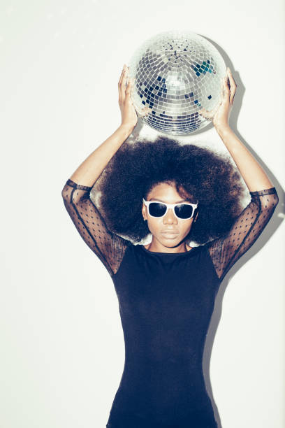 istock Woman holding disco ball over her head 1139107770