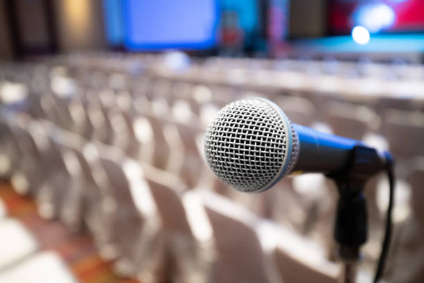 istock Microphone stand abstract blurred photo in conference hall or seminar room background, no people, 1139109376