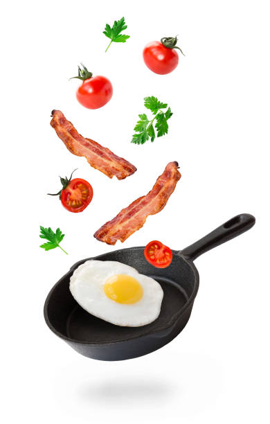 철 프라이팬으로 날고 있는 튀긴 달걀, 베이컨, 체리 토마토 - bacon isolated portion pork 뉴스 사진 이미지