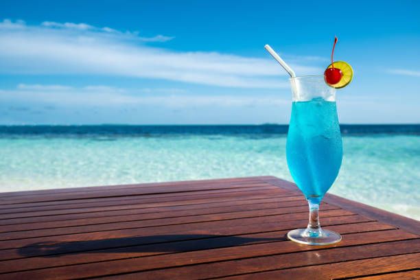 Blue lagoon cocktail on table and beautiful sea background stock photo