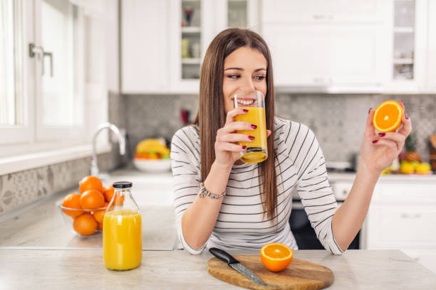 istock Close up Attractive Sensual Bare Woman drinking juice while Holding Sliced Orange Fruit. 1139113401