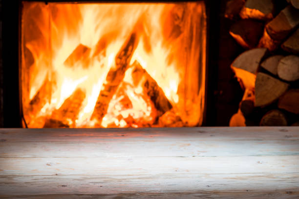 istock Wooden table top and burning warm fire. 1139114061