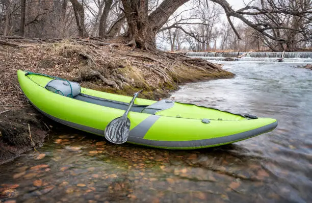 whitewater inflatable kayak on a river below diversion dam - Poudre River in Fort Collins, Colorado in early spring scenery