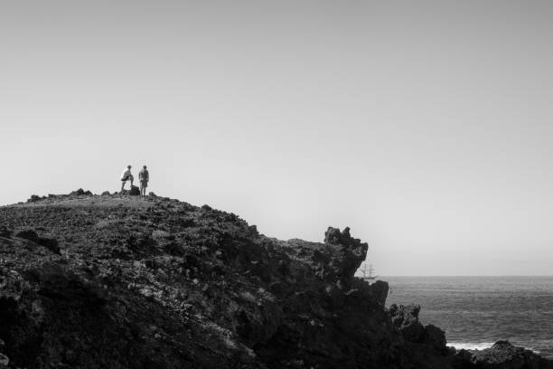 two men overlooking the atlantic ocean from the beautiful island of tenerife. - real people blue white friendship imagens e fotografias de stock