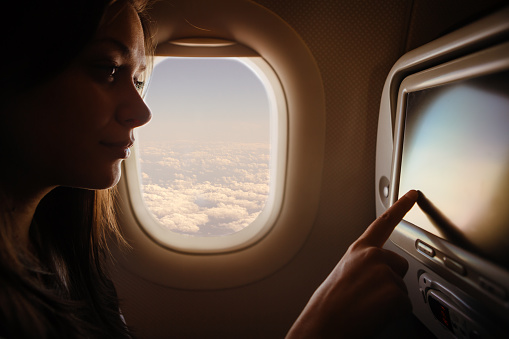 Woman using the touch screen on the airplane
