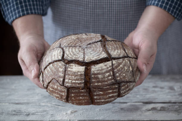 istock hands with bread on wooden background 1139125022