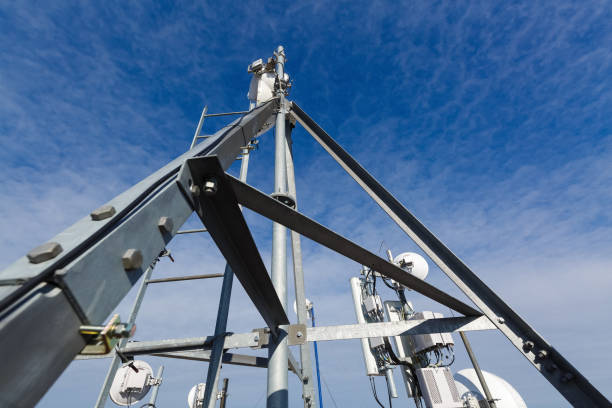 istock Metal construction for telecommunication data equipment  or mast with microwave, radio panel antennas, outdoor remote radio units, power cables, coaxial cables, optic fibers. Outside part of telecommunication basic station 1139128798