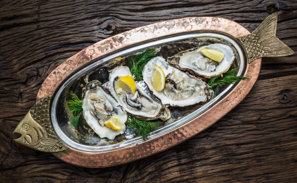 istock Opened oysters with piece of lemon. 1139128844