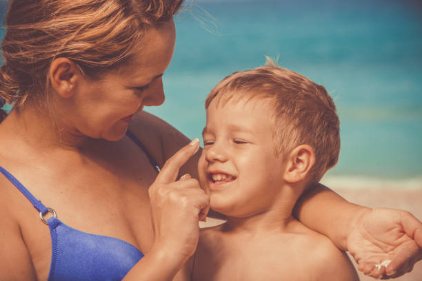 istock Mother putts sunscreen to boy's nose 1139130276