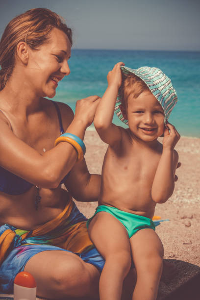 istock Boy taking off his hat at the beach 1139130285