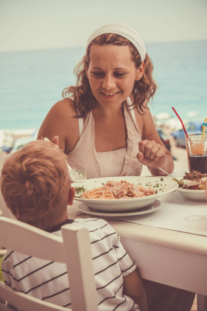 istock Mother and son having lunch in a beach restaurant 1139130289