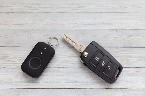 Opened Car Key with Remote Control on wooden background, close-up