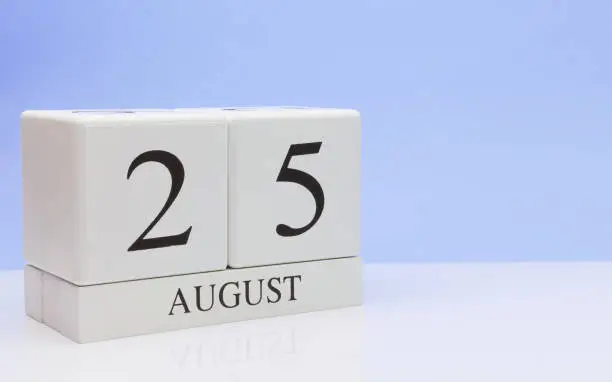 August 25st. Day 25 of month, daily calendar on white table with reflection, with light blue background. Summer time, empty space for text