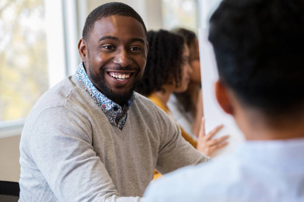 African American male is excited about job opportunities During the local job fair, a young adult African American male is happy to hear there are several job openings in his field. job fair stock pictures, royalty-free photos & images