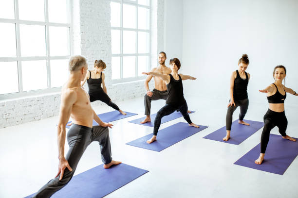istock Group of people practising yoga indoors 1139140421