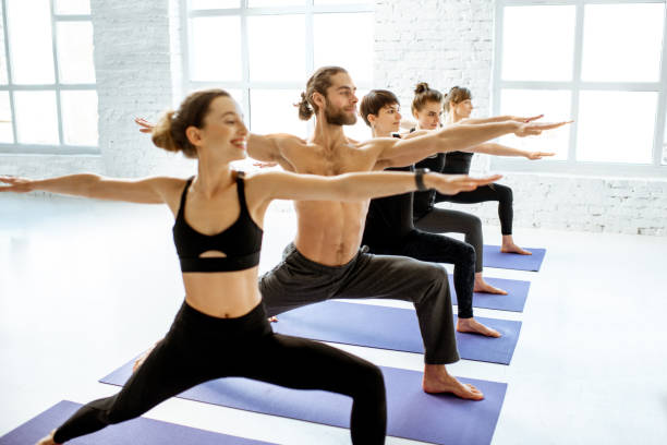 istock Group of people practising yoga indoors 1139140485