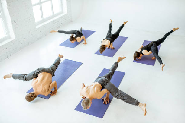 istock Group of people practising yoga indoors 1139140572