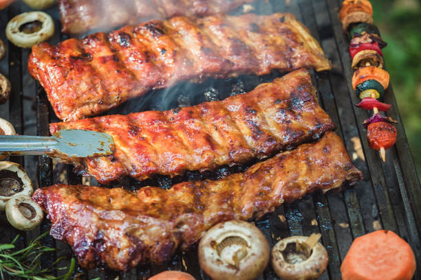 Preparing pork ribs on barbecue grill in nature